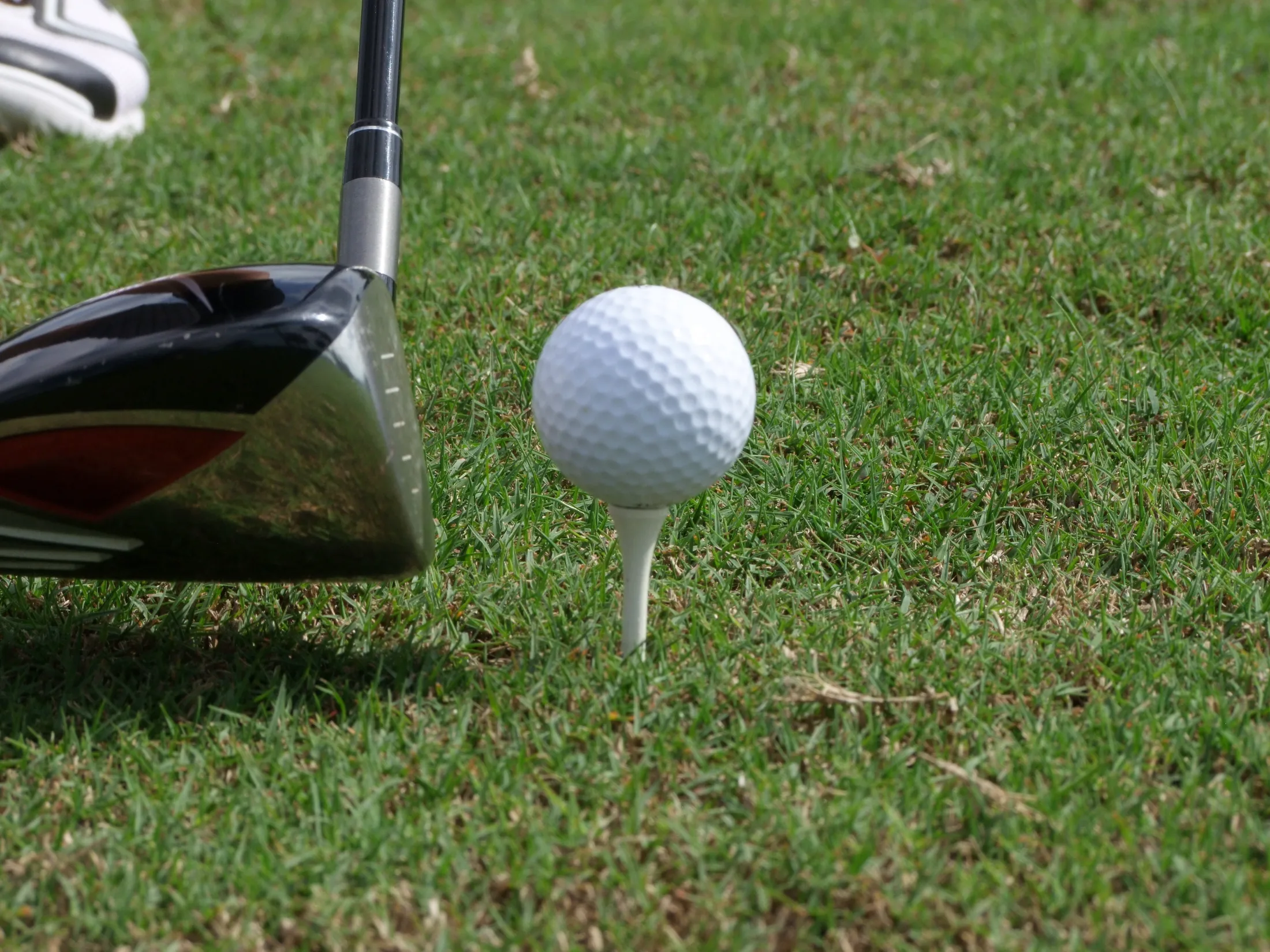 Close-up of a driver crown closing in on a teed ball, illustrating clubface and loft