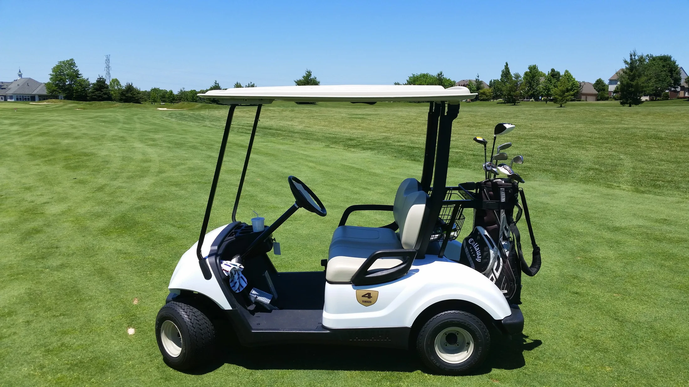 A modern electric golf cart parked on the cart path